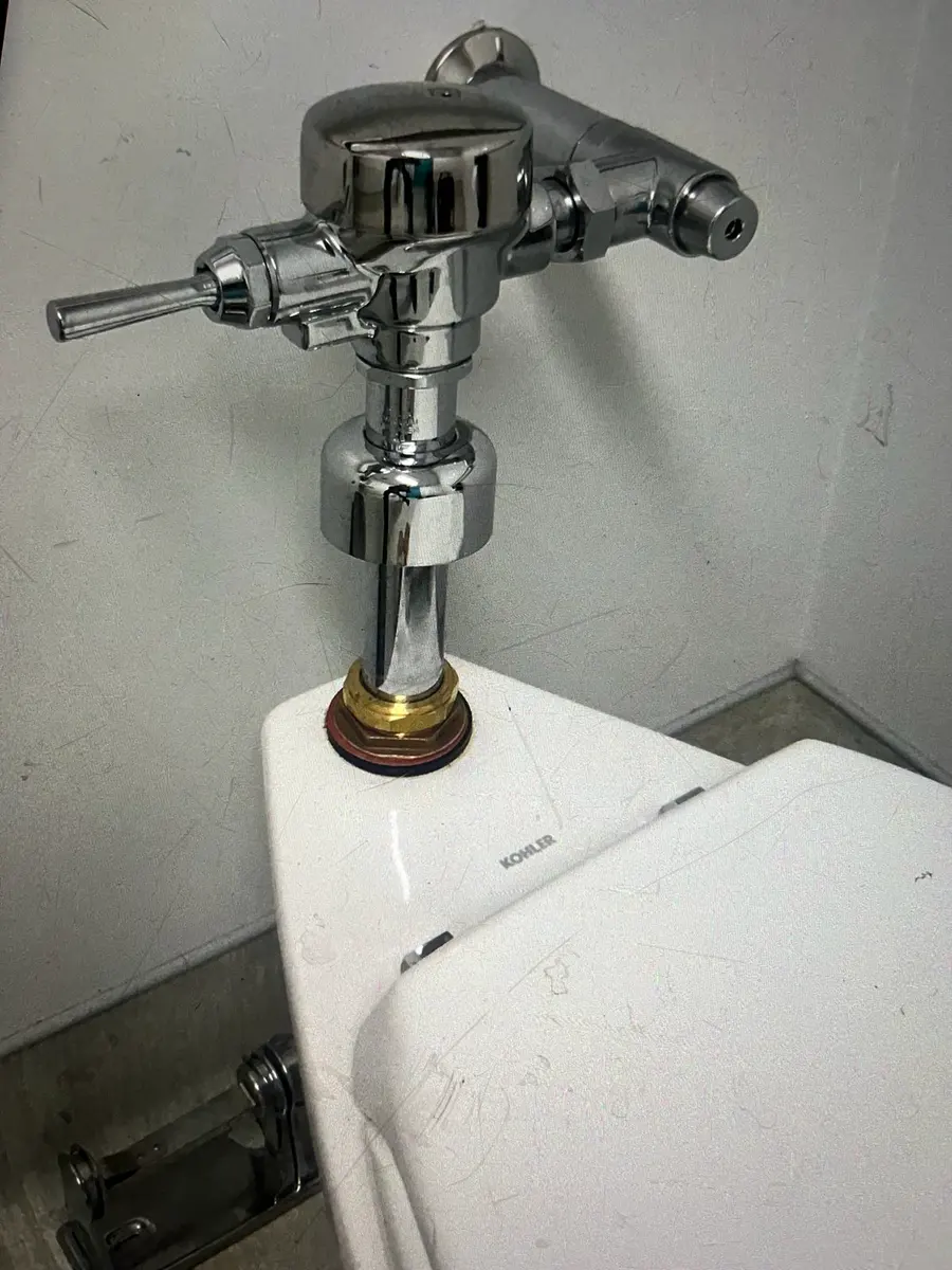 Chrome commercial toilet fixture installed by a plumber